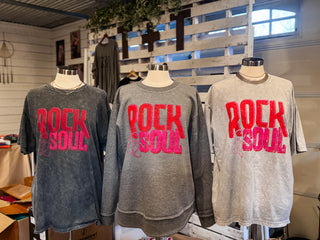 3 mannequins wearing graphic tees and sweatshirt in various shades of grey with the "rock & soul" design printed in pink and red inks