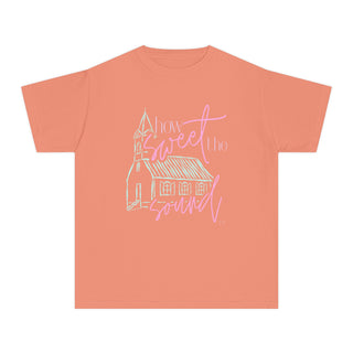 Coral t-shirt with a church graphic and 'How Sweet the Sound' text on a white background