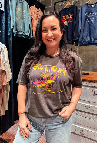 Woman wearing a vintage fit graphic t-shirt in a clothing store with a screen print design