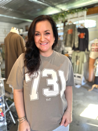 female wearing a 731 area code tee in a taupe color with jeans