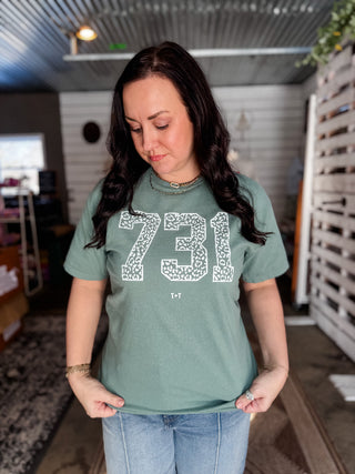 Woman wearing a green t-shirt with '731' design in a casual setting