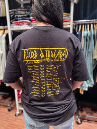 Person wearing a black t-shirt with yellow text in a clothing store