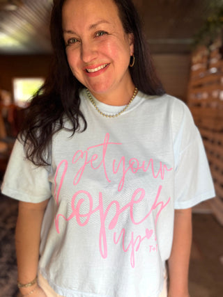 lady wearing a graphic tee that reads "get your hopes up" in her warehouse space