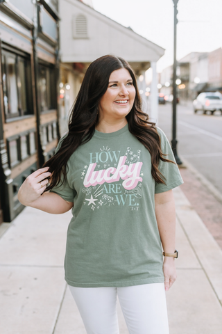 Woman wearing a green t-shirt with a colorful graphic design on a city street.