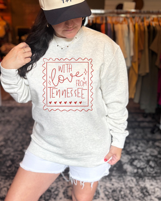 Person wearing a gray sweatshirt with 'With Love from Tennessee' text in a store setting.