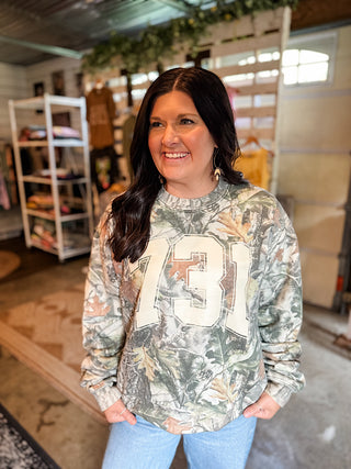 female model wearing blue jeans and an area code 731 west tn camo sweatshirt