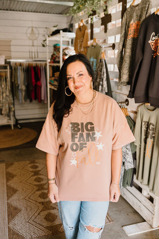 big fan of fall over sized graphic tee in a nude color  worn by a female model that reads "big fan of fall" paired with blue jeans in a she-shed