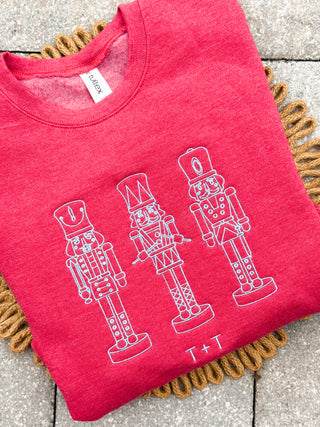 Red sweatshirt with nutcracker design embroidered with steel blue threaded