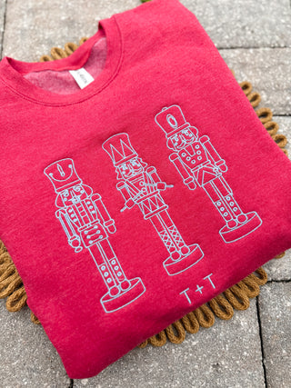 Red sweatshirt with white nutcracker design on a textured surface