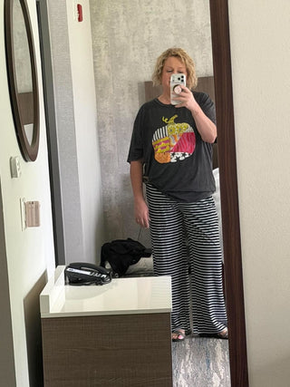 female model taking mirror selfie with patchy pumpkin tee in black