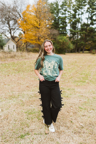 female model wearing a pine green short-sleeve next level tee with a graphic print printed in khaki ink featuring a butterfly and mushroom bohemian vibe design