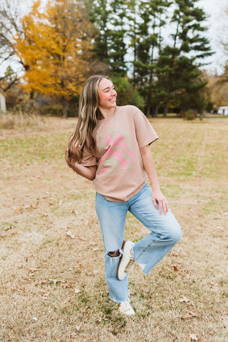 Woman standing in a field with trees and autumn leaves in the background