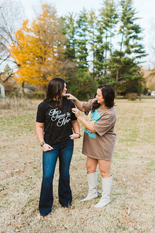 models fixing hair placement while modeling graphic tees