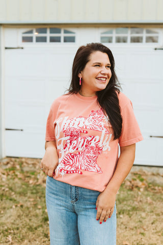 brunette female model wearing a comfort colors terracotta color short-sleeve tee with a white and red design that reads "shine fiercely" with tigers incorporated into the design